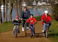Family cycling along the River Thames